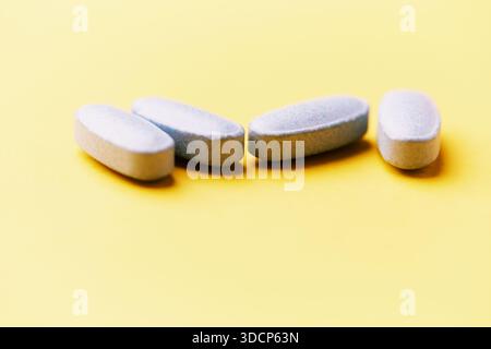 Multivitamintabletten auf hellem Papierhintergrund. Nahaufnahme. Kopierbereich Stockfoto