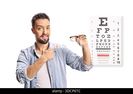 Glücklicher Mann mit einer Augenkarte, die neue Brille auf weißem Hintergrund hält Stockfoto