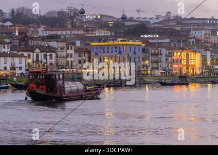 Gaia Stadtbild entlang des douro Flusses mit Ragelo-Boot und Seilbahnen in der Dämmerung Stockfoto
