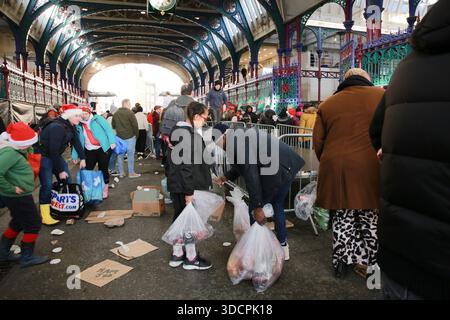 London, Großbritannien. 24. Dezember 2025. Die Besucher besuchen die jährliche Smithfield Market Christmas Eve Meat Auction entlang der Grand Avenue des Marktes in London. Die Menschenmassen kommen zusammen, um Truthühner, Enten, Hühner und Schweinefleisch, Rindfleisch und Lamm zu ermäßigten Preisen zu kaufen, während Händler überschüssiges Fleisch vor der Weihnachtssperre verkaufen. Potenzielle Käufer schwenken Banknoten, um die Aufmerksamkeit der Mitarbeiter von G. Lawrence Wholesale Meats, einem der an der Auktion teilnehmenden Händler, zu wecken. Die Veranstaltung, eine Londoner Tradition, die mehr als ein Jahrhundert zurückreicht, zieht sowohl professionelle Käufer als auch Mitglieder der Öffentlichkeit an. Credi Stockfoto