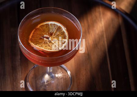 Whiskey-Cocktail oder manhattan serviert mit einer dehydrierten Orangenscheibe. Stockfoto