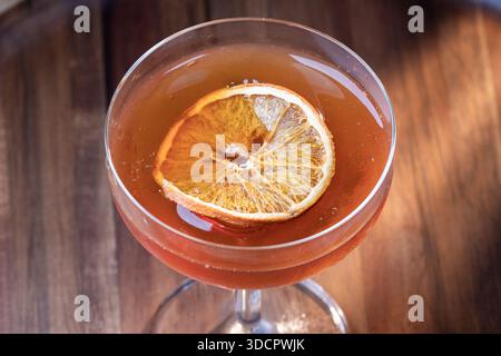 Whiskey-Cocktail oder manhattan serviert mit einer dehydrierten Orangenscheibe. Stockfoto