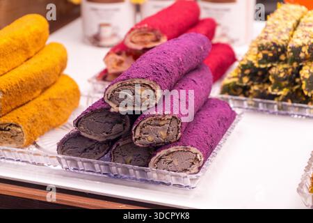 Türkischer Genuss in Form von Roll. Orientalische Süßigkeiten lokum. Violette Rolle mit Maulbeere und Pistazien. Süßes Essen Stockfoto