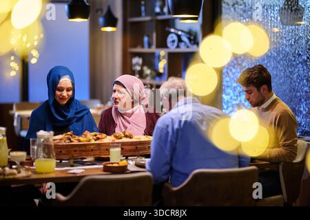 Muslimische Familie genießt iftar zusammen in einem Restaurant während der Ramadanfeier mit traditioneller Dekoration Stockfoto