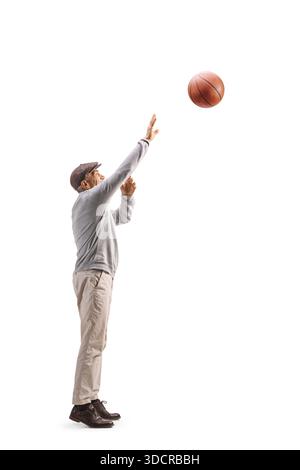 Profilaufnahme eines aktiven älteren Mannes, der Basketball spielt, isoliert auf weißem Hintergrund Stockfoto