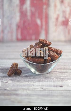 Getrocknete Datteln in einer Glasschale auf einem Holztisch Stockfoto