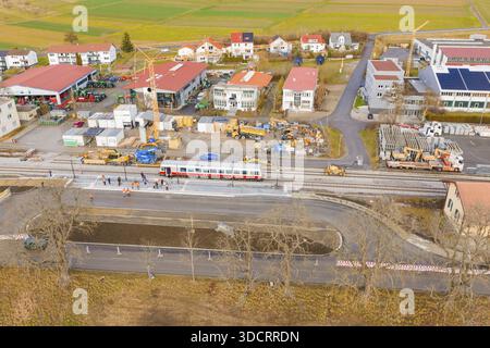 Eine Baustelle neben einem Zug, umgeben von Gebäuden und Feldern, wird aus der Luft gesehen, historisches Ereignis, erste Probefahrt mit einem Passagierwagen Stockfoto