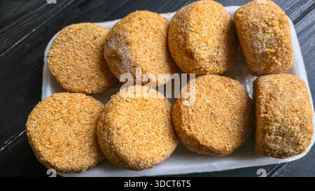 Frisch gefrorene panierte Fischkuchen. Runde, halbfertige Produkte, fertig zum Kochen. Fisch Und Meeresfrüchte. Stockfoto
