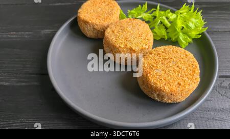 Frisch gefrorene panierte Fischkuchen. Runde, halbfertige Produkte, fertig zum Kochen. Fisch Und Meeresfrüchte. Stockfoto