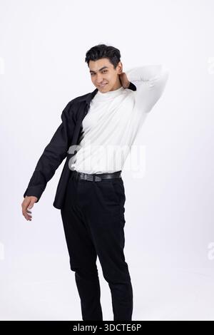 Junger Mann in weißem Hemd, der eine Jacke anzieht Stockfoto