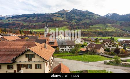 Albeuve Dorf Eglise Saint-Pierre-aux-liens weiße Kirche und Herbstlandschaft im Intyamon Tal. Haut-Intyamon, Freiburg, Schweiz. Stockfoto