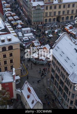 Ein erhöhter Winterblick zeigt den Breslauer Altstadtplatz, pastellfarbene Stadthäuser, Arkadenfassaden, Schnee auf Dächern, Holzbuden, Frostfedern und Leute in s Stockfoto