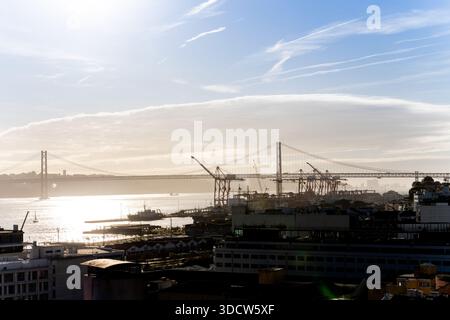 Lissabon Portugal Dezember 06 2025 Tele-Ansicht der Hängebrücken und Containerkräne entlang des Tejo-Flusses Stockfoto