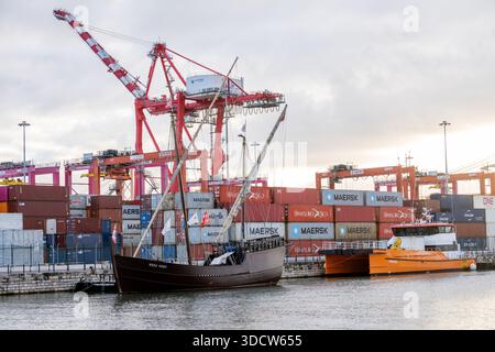 Lissabon Portugal 6. Dezember 2025. Das historische Segelschiff liegt auf dem Tejo mit Containerkränen und gestapelten Schiffscontainern im hinteren Teil Stockfoto