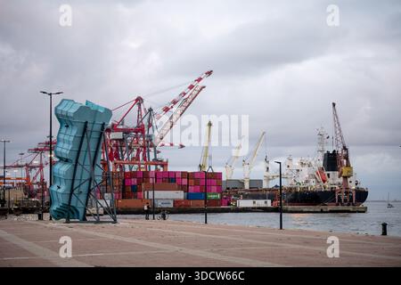 Lissabon Portugal 6. Dezember 2025. Das Frachtschiff wird am Hafen mit Kränen und gestapelten Containern entlang des Tejo-Flusses angedockt. Stockfoto