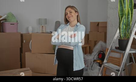 Schwangere Frau lächelt selbstbewusst im Wohnzimmer, umgeben von Umzugskästen, und zeigt einen Neuanfang in ihrem neuen Zuhause mit Pflanzen und Möbeln. Stockfoto