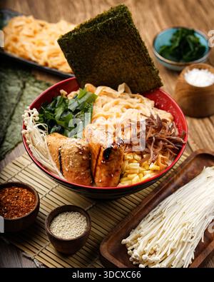 Eine Nahaufnahme einer dampfenden Schüssel japanischer Ramen mit perfekt gekochten Nudeln, herzhaftem Tofu, frischem Algen, Enoki-Pilzen und Mais. Garni Stockfoto
