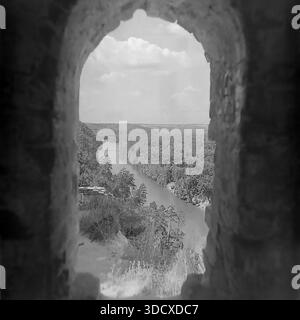 Ukraine, Region Donezk, Sviatohirsk, 1980er Jahre Ein archiviertes Schwarzweißfoto, das einen malerischen Blick auf den Seversky Donets River durch einen Steinbogen auf den Kreidefelsen macht. Der natürliche Rahmen zeigt einen sich windenden Fluss, üppige dichte Wälder und einen bewölkten Himmel, der charakteristisch für das Naturschutzgebiet Holy Mountains ist. Dieses künstlerische Vintage-Bild bewahrt die ruhige Atmosphäre der Landschaft in einem friedlichen Donbass vor dem Krieg und dient als wertvolles historisches Dokument dieser Zeit. Stockfoto