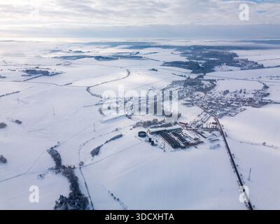 Ein Blick aus der Vogelperspektive zeigt eine schneebedeckte Landschaft im Winter, komplett mit einem kleinen Dorf Priseka und landwirtschaftlichen Gebäuden. Highland, Vysocina, C Stockfoto