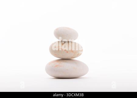 Ein ausgeglichener Stapel von drei glatten Flussfelsen, die aufeinander liegen. Perfekt für Zen-Balance, Meditation oder Spa-Konzepte. Stockfoto