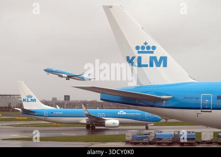 06.12.2024, Amsterdam, Nordholland, NLD - Flugzeuge der KLM auf dem Flughafen Schiphol. Abflug, Abheben, Fluggesellschaft, Flughafen, Alltag, Amsterdam, Amsterdam-Schiphol, Aussen, Aussenaufnahme, Boeing, Boeing 737, Emblem, Europa, europaeisch, Ferien, Fernreise, Flieger, Fluggesellschaft, Flughafen Schiphol, Fluglinie, Flugreise, Flugtechnik, Flugzeuge, Gesellschaft, Heck, Heckfluegel, Hollaendisch, Holland, Jahreszeit, Jets, KLM, Kofferwagen, Logo, Luftfahrt, Luftfahrtgesellschaft, niederlaendisch, Niederlande, niemand, Noord-Holland, Nordholland, Passagierflugzeuge, Passagiermaschinen, PH- Stockfoto