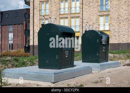 Neu installierte unterirdische Abfallbehälter für Papier („PAPIER“) und Restmüll („RESTAFVAL“) neben einem Wohnkomplex Stockfoto