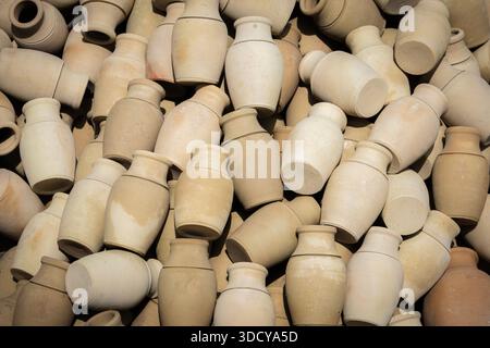 Töpfergefäße aus Tonwaren stapelten sich zusammen, um ein rustikales Muster für einen alten Kunsthandwerkshintergrund zu schaffen Stockfoto