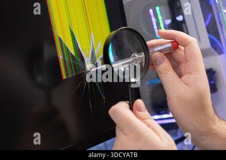 Die Nahaufnahme zeigt Hände, die ein zertrümmertes elektronisches Display mit farbigen Linien und Rissen inspizieren, was die Fehlersuche, technische Probleme und symbolisiert Stockfoto