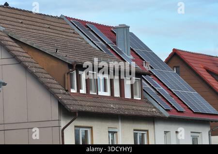 Wohnhäuser mit Solarpaneelen auf Dächern. Beispiel für die Nutzung erneuerbarer Energien in Privathaushalten und Vorstadtarchitektur. Stockfoto