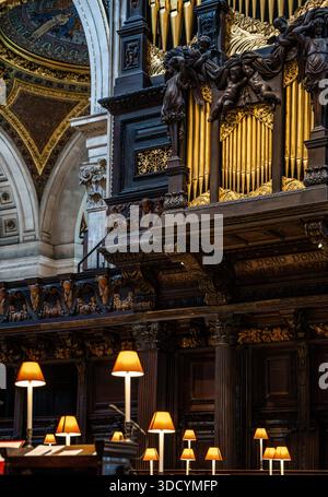 Die Orgel über dem Quire, wo Chor und Klerus während der Gottesdienste sitzen, mit warmen Lampen und geschnitzten Ständen in der St Paul's Cathedral in London, Großbritannien Stockfoto