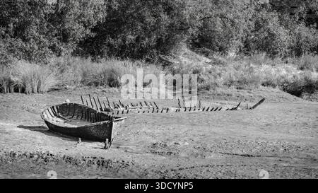 Zwei verlassene und zerstörte Boote am Ufer der Ria de Barro, Schwarzweiß, Schwarzweiß, 16:9 Stockfoto