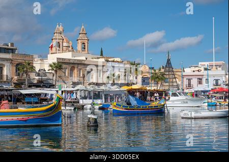 Sommeratmosphäre im Küstendorf Marsaxlokk mit farbenfrohen traditionellen Fischerbooten im alten Hafen Marsaxlokk, Malta, 11. Dezember 2025 Stockfoto