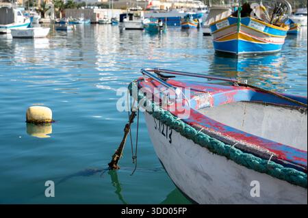 Sommeratmosphäre im Küstendorf Marsaxlokk mit farbenfrohen traditionellen Fischerbooten im alten Hafen Marsaxlokk, Malta, 11. Dezember 2025 Stockfoto
