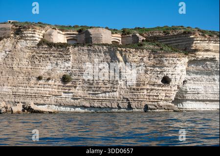 Spektakuläre Kreidefelsen und zerklüftete Kalksteinfelsen der Halbinsel Delimara an der südöstlichen Spitze Maltas, fotografiert vom Meer aus in der Sonne Stockfoto