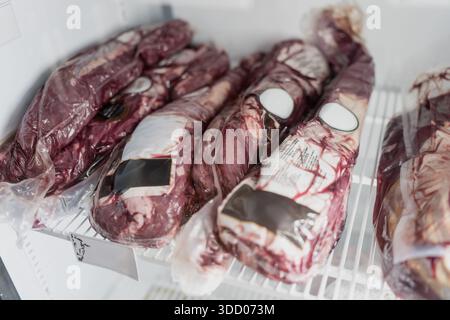 Rohe Rindfleischschnitte vakuumversiegelt und in professioneller Kühllagerung gelagert, mit Schwerpunkt auf Fleischverarbeitung, Großhandel und Logistik in der Lebensmittelindustrie Stockfoto
