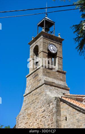 Ein steinerner Uhrenturm vor einem klaren blauen Himmel. Gebäude Stockfoto