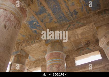Bemalte Decke und verzierte Säulen in einem alten ägyptischen Tempel, detaillierte Innenarchitektur Stockfoto