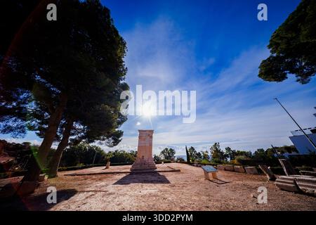 Eine breite, dramatische Aufnahme mit der hellen Sonne direkt über dem Torre de Sant Josep, die einen markanten Sonnenaufgang und tiefe Schatten über dem trockenen Boden erzeugt Stockfoto