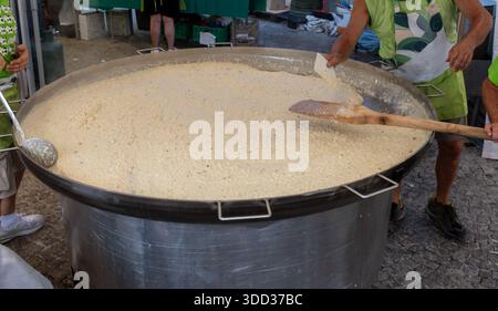 Kochen von Risotto mit Gorgonzola cremigem Blauschimmelkäse in einer riesigen Pfanne auf dem lokalen Festival in Gorzonzola Stadt, Lombardei, Italien Stockfoto