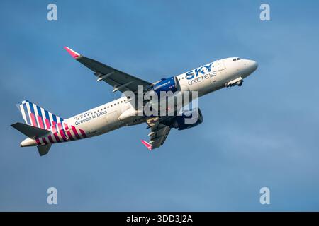 Brüssel, Belgien - 21. Dezember 2025: Passagierflugzeug des Sky Express Airbus A320 startet vom Flughafen Brüssel, von unten gesehen vor klarem blauem Himmel. Stockfoto