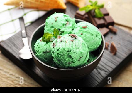 Leckeres Minzschokolade-Eis serviert auf Holztisch, Nahaufnahme Stockfoto