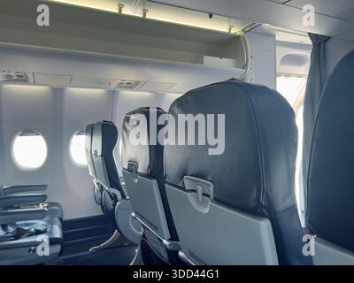 Innenraum der Flugzeugkabine mit nicht belegten Passagiersitzen, Fenstern und Dachfächern Stockfoto