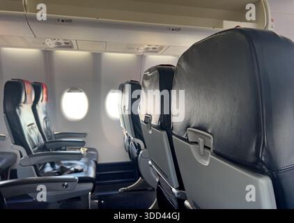 Leere Flugzeugkabine mit Reihen von Passagiersitzen und Fenstern Stockfoto