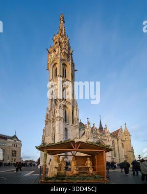 Dies ist ein Adventsmarkt im Buda Castle, der Fischerbastei. Im Hintergrund befindet sich die berühmte Matthiaskirche. Die Leute laufen herum, stöbern, an Stockfoto