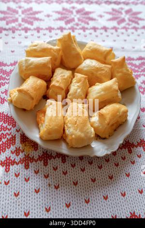 Nahaufnahme von frisch gebackenem herzhaftem Käsegebäck mit einer knusprigen goldenen Kruste. Hausgemachte Vorspeise auf einem Holzbrett mit selektivem Fokus. Stockfoto