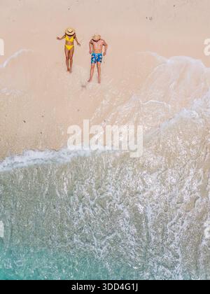 Besucher genießen einen sonnigen Tag am Playa Kalki Beach in Westpunt, Curacao. Der goldene Sand und das klare Wasser bilden einen perfekten tropischen Urlaub für Entspannung und Spaß unter der Sonne. Draufsicht der Drohne Stockfoto