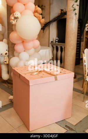 Nahaufnahme einer rosafarbenen Geschenkbox mit Band - Dekor für Kinderparty. Stockfoto