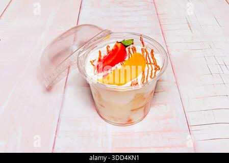 Individuelle Portion Tres Leches Cake, serviert in einem Glas, mit den Schichten von eingeweichten Biskuitkuchen, Schlagsahne und dekoriert mit gemahlenem ci Stockfoto