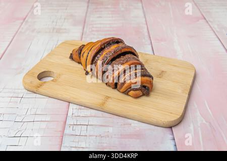 Vollkorncroissant aus Dinkelmehlteig, serviert mit Avocado-Püree und pochiertem Ei – eine gesunde Frühstücksoption Stockfoto