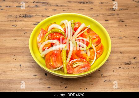 Tomaten- und Frischkäsesalat mit halbierten Kirschtomaten in verschiedenen Farben, zerbröckelten Fetakäsewürfeln, Kalamata-Oliven und einem Hauch getrockneter Oreg Stockfoto